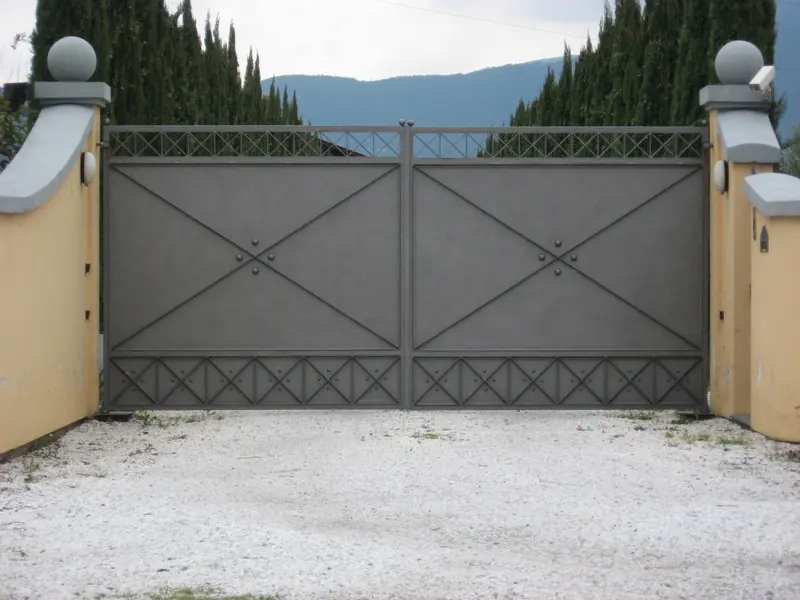 Cancello a battente cieco automatico su vialetto in ghiaia