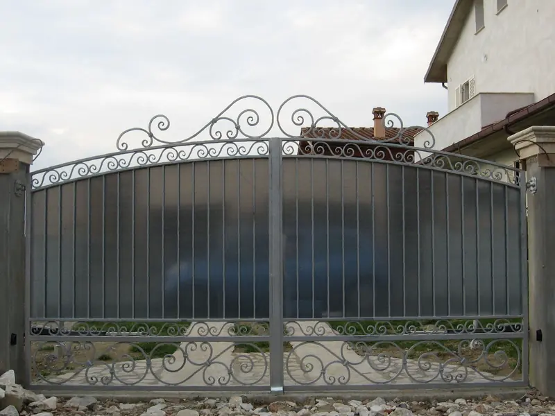 Cancello a battente cieco con volute in ferro battuto, automatizzato
